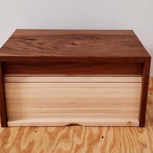 Stillvolle Zirbenbrotdose: Korpus aus Nussbaum, Lamellen aus Zirbenholz.