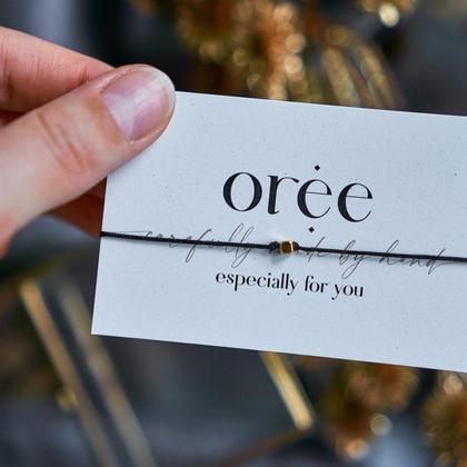 Schwarzes Armband mit goldener Perle