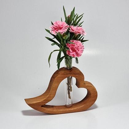 Herz aus Holz liegend mit Vase