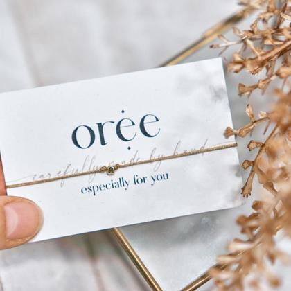 Braunes Armband mit goldener Perle