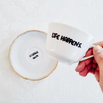 Vintage-Tasse mit Untertasse "Life happens"